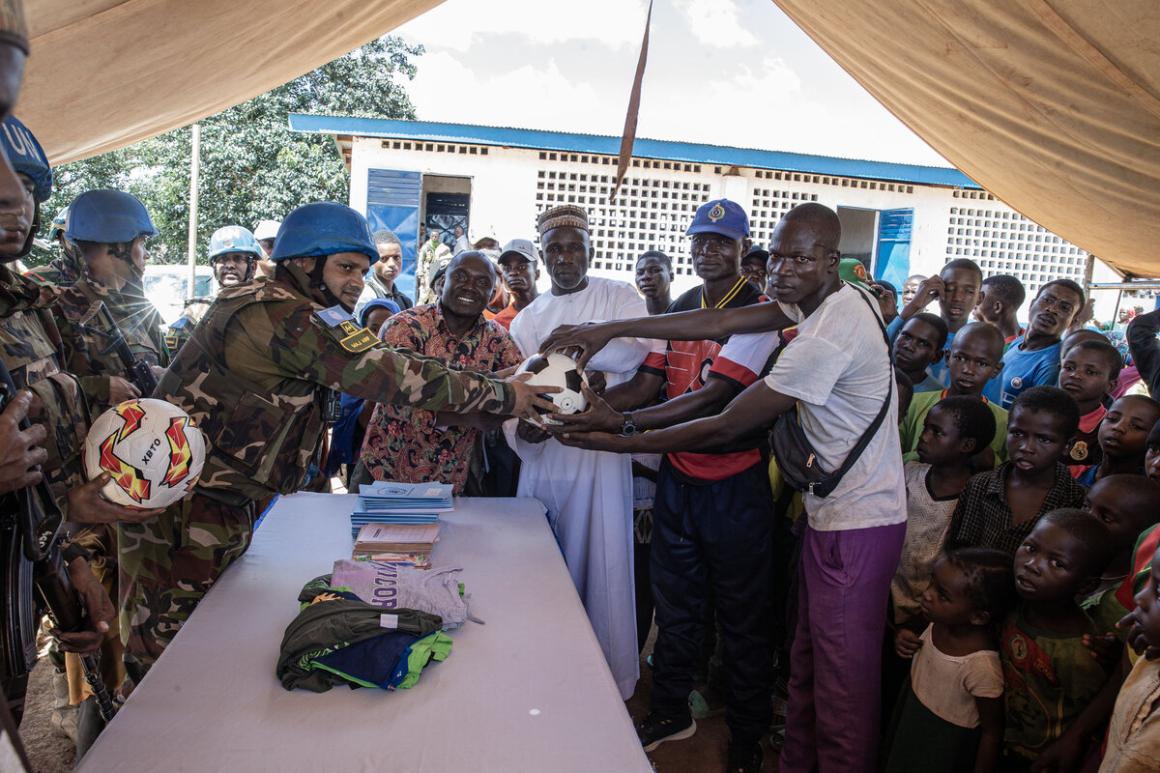 A group poses with sports equipment.